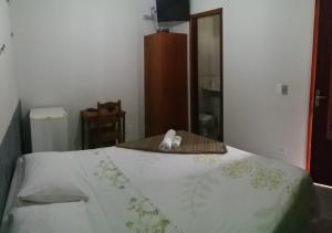 a bedroom with a bed with a towel on it at Pousada Casagrande - São João in Volta Redonda