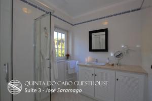 a white bathroom with a shower and a sink at Quinta do Cabo Guesthouse in Sintra