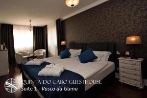 a bedroom with a bed with blue and white pillows at Quinta do Cabo Guesthouse in Sintra