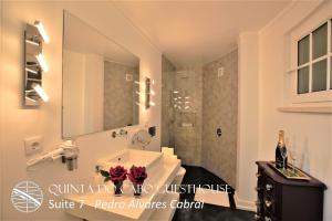 a bathroom with a sink and a glass shower at Quinta do Cabo Guesthouse in Sintra