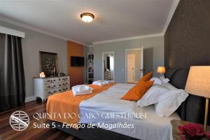 a bedroom with a large bed with orange sheets and pillows at Quinta do Cabo Guesthouse in Sintra