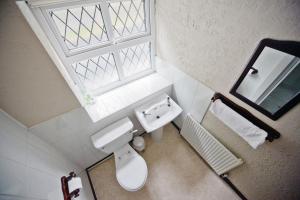 uma casa de banho com um WC, um lavatório e uma janela em The Lantern Pike Inn em Hayfield