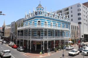 a blue building on a city street with cars at Urban Hive Backpackers in Cape Town