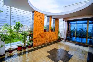 a lobby with a large room with windows and plants at HOTEL LAKE CASTLE - Parkview in Dhaka