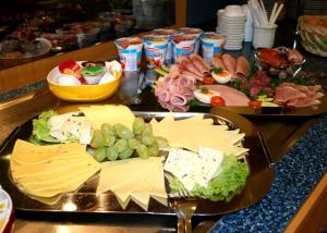 two trays of food on a table with cheese and grapes at Pension ABC in Berlin