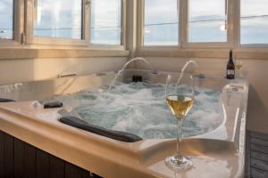 een glas wijn in een bad met een glas wijn bij Apartments Villa Lux in Dugi Rat