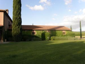 dom z zielonym trawnikiem przed nim w obiekcie Agriturismo Podere Sant' Antonio w mieście Alberese