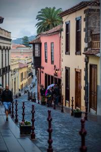 
people walking down a street with umbrellas at Hotel Rural Orotava in La Orotava
