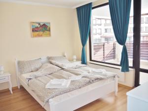 
A bed or beds in a room at Firefly Apartments Pamporovo
