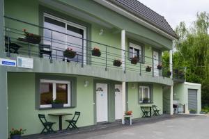 un edificio verde con mesa y balcón en Gîte des Mesanges, en Haybes