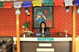 une femme assise au comptoir d'un restaurant dans l'établissement Kathmandu Village House, à Katmandou