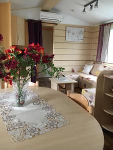 a table with a vase with red flowers on it at Lo Soulenquo à Fonteilles sur le GR 65 in Golinhac