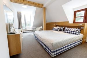 a bedroom with a bed with blue and white pillows at Hotel Bedriska Wellness Resort & Spa in Špindlerův Mlýn