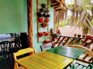 a wooden table on a balcony with potted plants at Pousada Praia da Lagoinha in Bombinhas