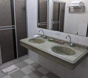 a bathroom with two sinks and a shower at Hotel Huaka-yo in San Agustín