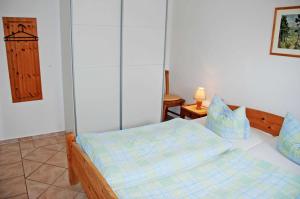 una camera da letto con un letto con lenzuola blu sopra di Ferienappartements Gaude Stuv a Ostseebad Sellin