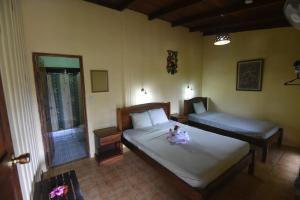 PitalにあるLa Laguna del Lagarto Eco-Lodgeのベッドルーム1室(ベッド2台、人形付)