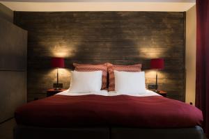 een slaapkamer met een groot rood bed met 2 lampen bij Hotell Nordic in Norrköping