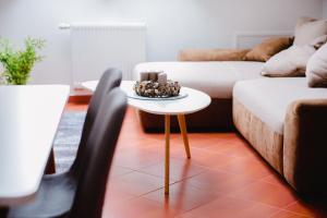 ein Wohnzimmer mit einem Tisch und einem Sofa in der Unterkunft Nexus Apartmenthotel in Hévíz