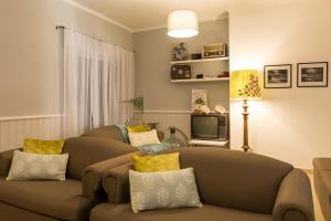 ein Wohnzimmer mit einem Sofa und einem TV in der Unterkunft Casa Areal de Santa Barbara in Ribeira Grande