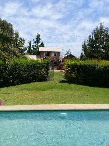 a house behind a yard with a swimming pool at Parcela 9 Nehuen in Talagante