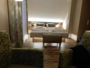 ein Hotelzimmer mit 2 Betten und einem Stuhl in der Unterkunft Hotel Pension Am Hafen in Norddeich