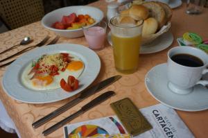 una mesa con un plato de huevos y fruta y una taza de café en Alfiz Hotel, en Cartagena de Indias