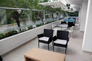 a row of tables and chairs on a balcony with windows at Blu Hotel by Tamaca in Santa Marta