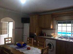 a kitchen with a table and a kitchen with a sink at A quinta do Avo Jorge in Martingança