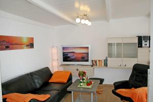 オストゼーバート・ゼリンにあるFerienhaus Maritのリビングルーム(黒い革張りのソファ、テレビ付)
