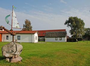eine Kirche mit einem Kirchturm und einem Felsen im Hof in der Unterkunft Ferienwohnung an der Deichwiese in Lobbe