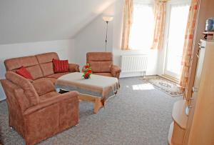 a living room with a couch and two chairs at Ferienwohnung Schwalbennest in Baabe