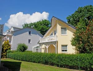 a house with a fence in front of it at Ferienwohnung Schwalbennest in Baabe