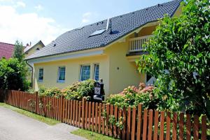 バーベにあるFerienwohnung Schwalbennestの木塀と花の黄色い家