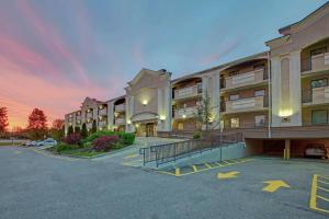 a large apartment building with a parking lot at Travelodge by Wyndham Parsippany in Parsippany