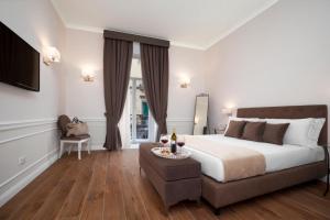 a bedroom with a large bed and a couch at La Fontanina Suites in Naples