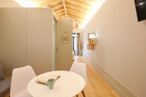 een witte eetkamer met een witte tafel en stoelen bij LOFT Sá de Noronha in Porto