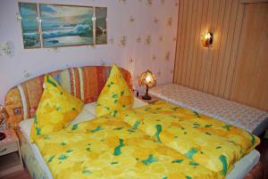 ein Schlafzimmer mit einem Bett mit gelber Decke in der Unterkunft Ferienwohnung Sehlen auf Rügen in Sehlen
