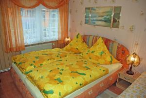 a bedroom with a large bed with a yellow comforter at Ferienwohnung Sehlen auf Ruegen in Sehlen