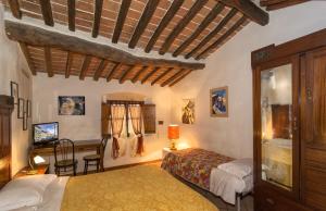 a bedroom with two beds and a table and a desk at Due Borghi Guest House in Pisa