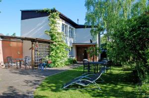 a house with a table and chairs in the yard at Ferienwohnungen am Heideweg in Baabe