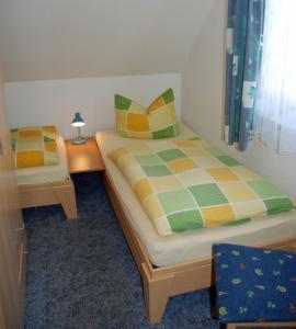 a bedroom with two beds and a table with a lamp at Ferienwohnungen Familie Looks in Klein Zicker