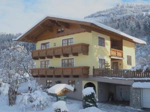 een huis met een balkon in de sneeuw bij Rohrmoser Appartements in Sankt Johann im Pongau