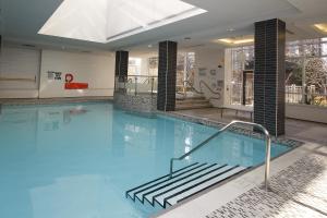 a large swimming pool with stairs in a building at Platinum Suites Furnished Executive Suites in Mississauga