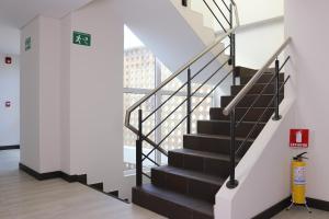 una escalera en un edificio con barandillas blancas y negras en Arame Hotel, en Envigado
