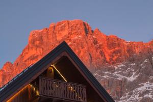 a building in front of a red mountain at Residence Langes in San Martino di Castrozza