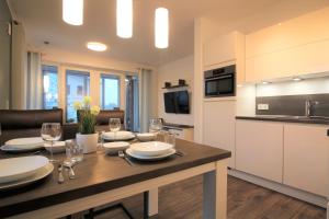 a kitchen and living room with a table with wine glasses at Wohnen am Yachthafen W25 in Cuxhaven