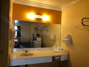 La salle de bains est pourvue d'un lavabo et d'un grand miroir. dans l'établissement Americas Best Value Inn-Mojave, à Mojave