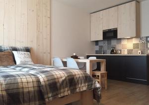 een slaapkamer met een bed en een tafel en een keuken bij Apartmány na sjezdovce Dolní Morava in Dolní Morava