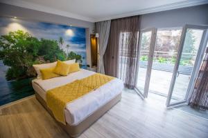 a bedroom with a bed with yellow sheets and windows at Double Bond Hotel Spa in Ankara